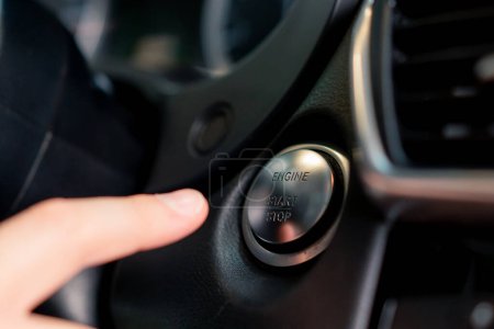 Téléchargez les photos : Homme appuie sur le bouton de démarrage de sa voiture de luxe noir intérieur de voiture - en image libre de droit