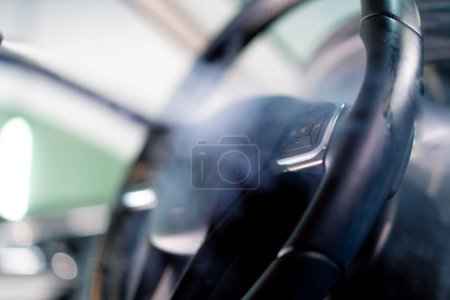 Foto de Un trabajador de lavado de coches limpia cuidadosamente el interior de un coche de lujo con un trapo una aspiradora de cepillo vaporizador detallando - Imagen libre de derechos