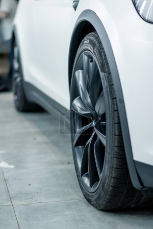 Téléchargez les photos : Détail - la roue d'une voiture de luxe blanche après un lavage de voiture à une station-service automobile - en image libre de droit