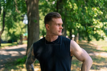 Photo for Portrait of young sweaty sportsman with tattoos and piercings looking pensive outdoors outdoor workout in park motivation - Royalty Free Image