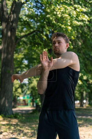 Foto de Retrato joven deportista enfocado haciendo ejercicio de calentamiento al aire libre calle entrenamiento parque motivación - Imagen libre de derechos