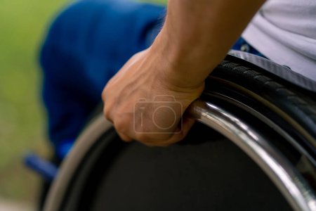 Foto de Inclusividad Primer plano de la mano de un hombre con discapacidad que monta una silla de ruedas en el parque de la ciudad - Imagen libre de derechos