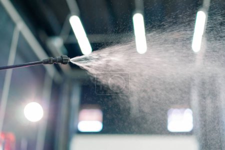 Photo for Close-up of the moment of spraying water from the sprayer during car washing - Royalty Free Image