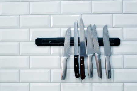Téléchargez les photos : Gros plan d'un ensemble de couteaux accrochés au mur dans la cuisine professionnelle du restaurant de sushi - en image libre de droit