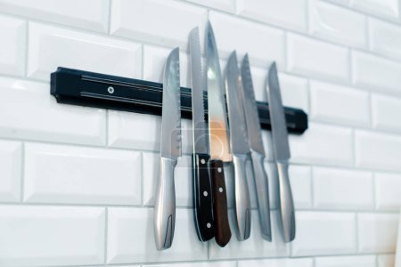 Téléchargez les photos : Gros plan d'un ensemble de couteaux accrochés au mur dans la cuisine professionnelle du restaurant de sushi - en image libre de droit