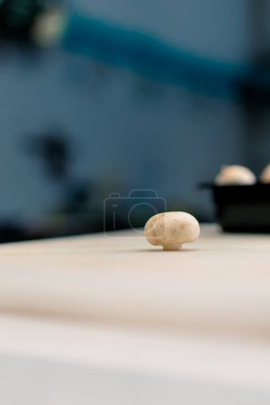 Téléchargez les photos : Gros plan d'un champignon sur une table de cuisine professionnelle le concept de la cuisine aimante et le processus de découpe des légumes - en image libre de droit