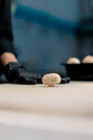 Téléchargez les photos : Gros plan d'un champignon sur une table de cuisine professionnelle le concept de la cuisine aimante et le processus de découpe des légumes - en image libre de droit