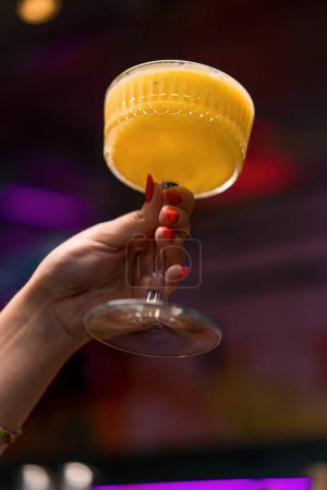 Téléchargez les photos : Gros plan des mains du client du bar tenant des cocktails alcoolisés concepts dans le bar ou le club - en image libre de droit