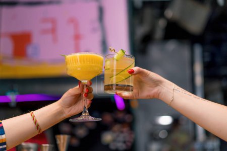 Foto de Primer plano de dos personas animando cócteles en el bar o discoteca bebidas y cócteles concepto - Imagen libre de derechos