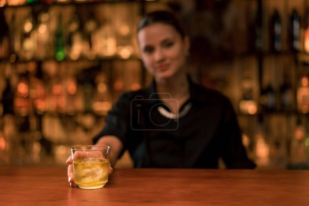 Foto de Primer plano de una chica camarera poniendo un cóctel con hielo en el bar y sirviéndolo al cliente - Imagen libre de derechos