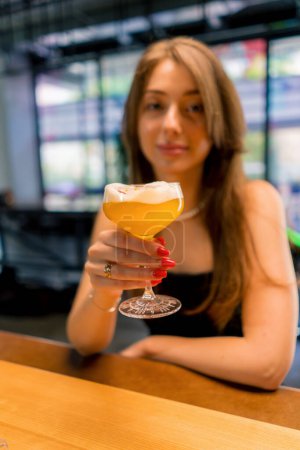 Foto de Retrato de una joven sonriente detrás de un bar en un club con delicioso cóctel alcohólico - Imagen libre de derechos