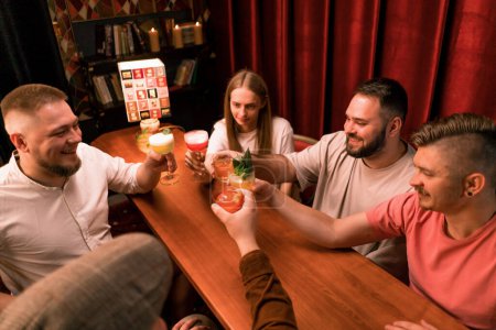 Téléchargez les photos : Un groupe d'amis dans un bar boire des cocktails et s'amuser Toasting cocktails Lunettes dans le club bar close-up - en image libre de droit