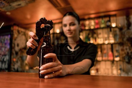 Foto de Primer plano de una camarera abriendo una botella de cerveza de vidrio cerrada en el bar del club - Imagen libre de derechos