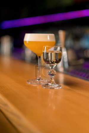 Foto de Primer plano de un delicioso cóctel alcohólico recién preparado de pie en el mostrador del bar en un club nocturno - Imagen libre de derechos