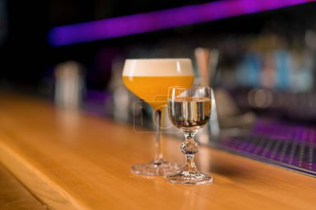 Foto de Primer plano de un delicioso cóctel alcohólico recién preparado de pie en el mostrador del bar en un club nocturno - Imagen libre de derechos