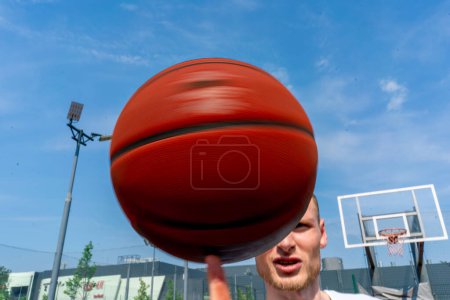 Photo for Close-up of guy basketball player spinning a basketball on his finger showing his basketball freestyle skills - Royalty Free Image