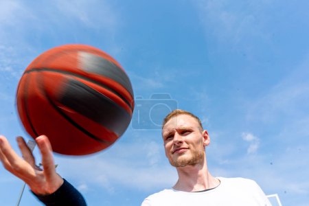 Foto de Primer plano del jugador de baloncesto chico haciendo girar una pelota de baloncesto en su dedo mostrando sus habilidades de baloncesto estilo libre - Imagen libre de derechos