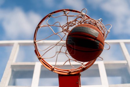 Photo for A close-up of basketball hoop into which a basketball hits the concept of admiration for the game of basketball and love of working out - Royalty Free Image