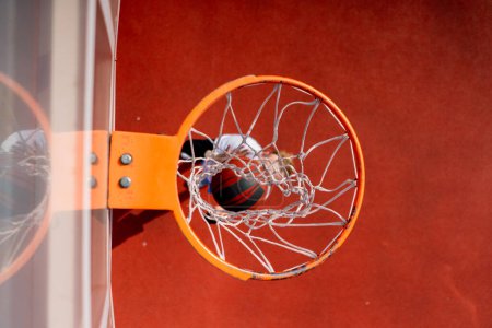 Photo for Close-up of basketball ring into which a tall guy basketball player throws the ball from below the concept of admiring the game of basketball - Royalty Free Image