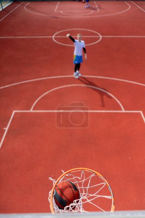 Téléchargez les photos : Gros plan de l'anneau de basket dans lequel un grand joueur de basket-ball lance la balle Le concept d'admirer le jeu de basket-ball - en image libre de droit