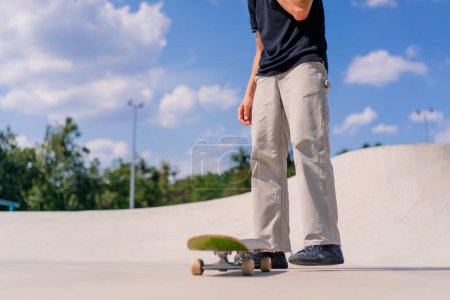 Foto de Close-up Un joven patinador lanza un monopatín con las manos y trata de hacer un truco en el parque de skate de la ciudad - Imagen libre de derechos
