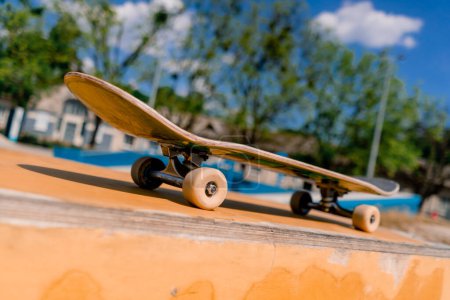 Photo for A close-up of a skateboard that stands on a bench in city skatepark the concept of adrenaline craving and love for skateboarding - Royalty Free Image