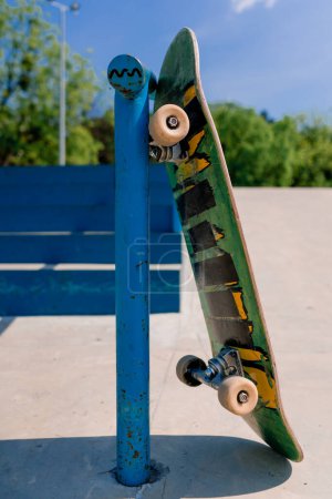 Photo for A close-up of a skateboard rotating while leaning on hand rails in city skatepark the concept of love for adrenaline and skateboarding - Royalty Free Image