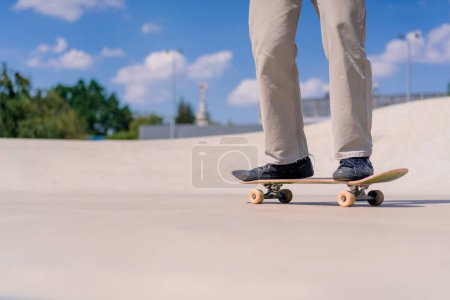Photo for Young guy skateboarder skateboarding around the city skatepark next to the figures for stunts close-up - Royalty Free Image