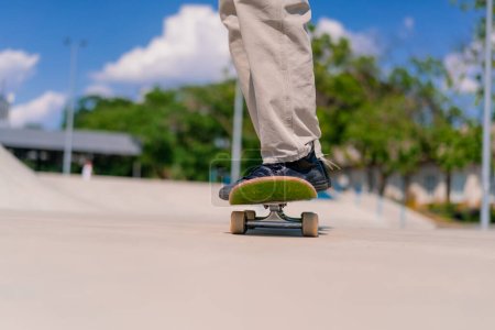 Foto de Joven skateboarder skateboarding alrededor de la ciudad skatepark junto a las figuras de acrobacias de cerca - Imagen libre de derechos
