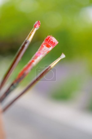Photo for Close-up of three painting brushes of different sizes in paint the concept of admiration for oil painting - Royalty Free Image