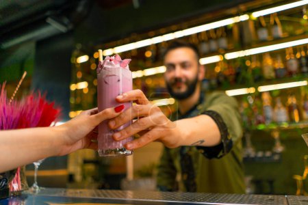 Foto de Camarero manos un cóctel fresco brillante sabroso para un huésped en un bar o restaurante de cerca manos - Imagen libre de derechos