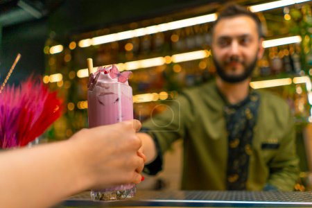 Foto de Camarero manos un cóctel fresco brillante sabroso para un huésped en un bar o restaurante de cerca manos - Imagen libre de derechos