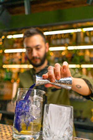 Téléchargez les photos : Barman professionnel crée une boisson cocktail verse de l'alcool dans un verre à mesurer au bar - en image libre de droit