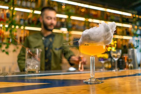 Téléchargez les photos : Cocktail alcoolisé frais et savoureux avec barbe à papa sur le comptoir du bar ou du restaurant - en image libre de droit