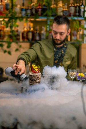 Foto de Barman profesional vierte cerca de alcohol fresco delicioso cóctel nitrógeno líquido hermosa y espectacular porción de bebida en el bar restaurante - Imagen libre de derechos