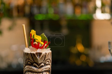 Photo for A freshly prepared alcoholic cocktail with a piece of pineapple stands on the bar counter in bar club - Royalty Free Image