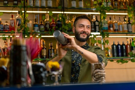 Téléchargez les photos : Le processus de fabrication d'un cocktail dans un bar Un barman mélange les ingrédients d'un cocktail alcoolisé en secouant shaker - en image libre de droit