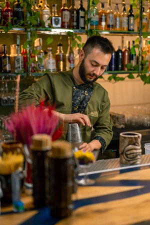 Téléchargez les photos : Le processus de fabrication d'un cocktail dans un bar Un barman mélange les ingrédients d'un cocktail alcoolisé en secouant shaker - en image libre de droit