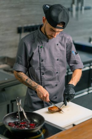 Téléchargez les photos : Restaurant professionnel chef de cuisine coupe délicieux poitrines de canard rôties avec couteau cuisine asiatique - en image libre de droit