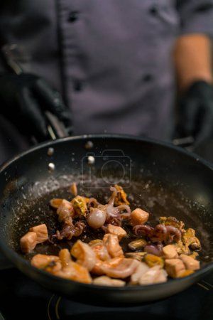Téléchargez les photos : Cuisine professionnelle dans le restaurant de l'hôtel close-up fruits de mer frits sur la casserole crevettes calmar moules saumon pétoncles - en image libre de droit