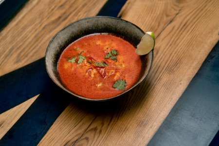 Photo for Close-up of delicious freshly prepared spicy red tom yum soup with seafood restaurant asian cuisine - Royalty Free Image