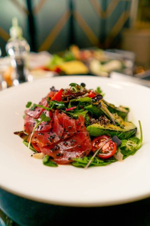 Téléchargez les photos : Gros plan d'une salade avec confiture d'avocats et tomates cerises préparée dans la cuisine professionnelle du restaurant italien - en image libre de droit