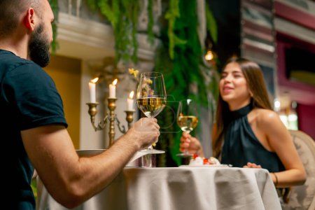 Foto de Joven pareja chico y chica sentado en un restaurante italiano dulcemente charlando y beber vino, mientras que en la fecha - Imagen libre de derechos