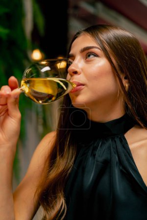 Foto de Primer plano de una linda joven bebiendo vino delicioso caro durante una cita en un restaurante italiano - Imagen libre de derechos