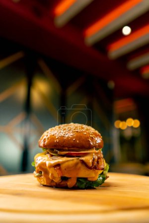Photo for A close-up of a burger with beef patty with vegetables and cheese cooked in the professional kitchen of Italian restaurant - Royalty Free Image