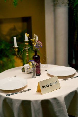 Téléchargez les photos : Gros plan sur le panneau de réservation réservé debout sur une table dans un restaurant italien de luxe cher - en image libre de droit