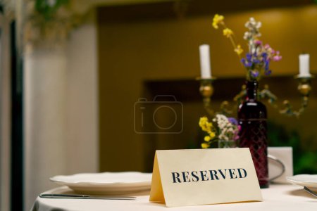 Téléchargez les photos : Gros plan sur le panneau de réservation réservé debout sur une table dans un restaurant italien de luxe cher - en image libre de droit