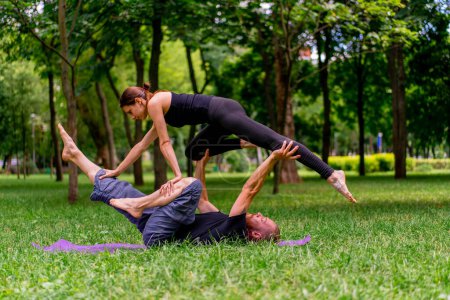 Photo for Couple in love or yoga instructor and woman doing exercises in city park asana spiritual practice healthy body stretch muscles support - Royalty Free Image