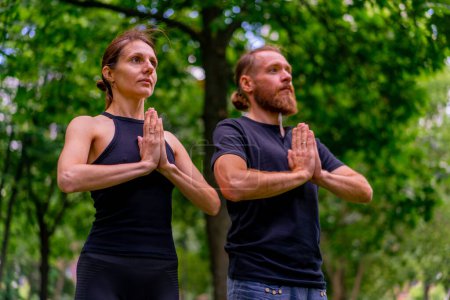 Foto de Retrato de una pareja practicando yoga en un parque de la ciudad haciendo ejercicios de meditación con gestos namaste la gente se centra en la salud mental y espiritual - Imagen libre de derechos