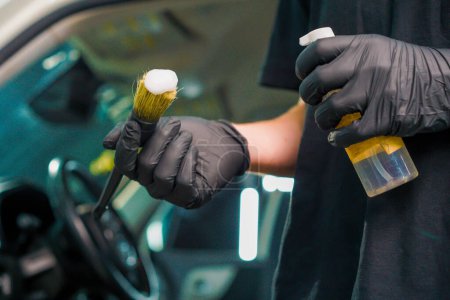 Photo for Close-up of car wash worker applying car wash foam to a brush while washing a luxury car during the detailing process - Royalty Free Image